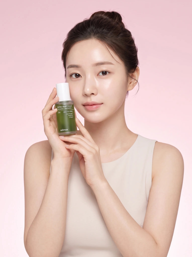 Celimax The Real Noni Energy Ampoule 30ml. Modelo aplicando el suero facial para nutrir e iluminar la piel.