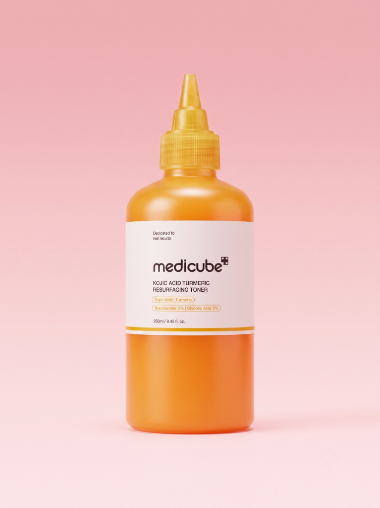 Envase del tónico exfoliante Medicube Kojic Acid Turmeric sobre fondo rosa de estudio