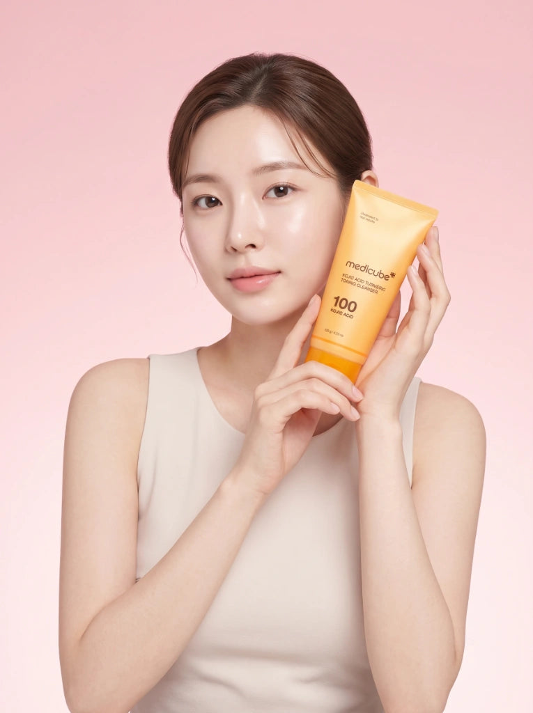 Medicube Kojic Acid Turmeric Toning Cleanser. Modelo sosteniendo el limpiador de ácido kójico en la mano.