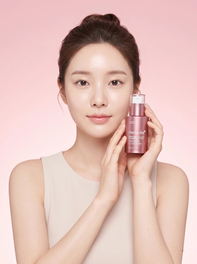 Medicube PDRN Pink Collagen Exosome Shot Serum 7500. Modelo sosteniendo el frasco del sérum en la mano.