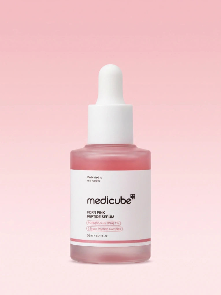 Medicube PDRN Pink Peptide Serum. Frasco del suero revitalizante rosa aislado sobre un fondo de estudio.