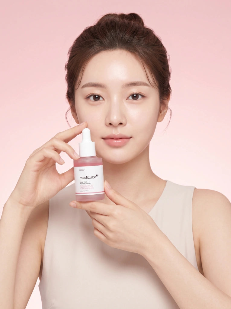 Medicube PDRN Pink Peptide Serum. Modelo sosteniendo el frasco del suero facial de péptidos en la mano.
