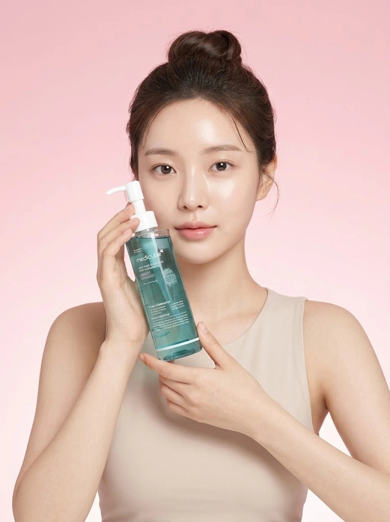 Medicube Zero Pore Blackhead Deep Cleansing Oil. Modelo sosteniendo el frasco del aceite desmaquillante.