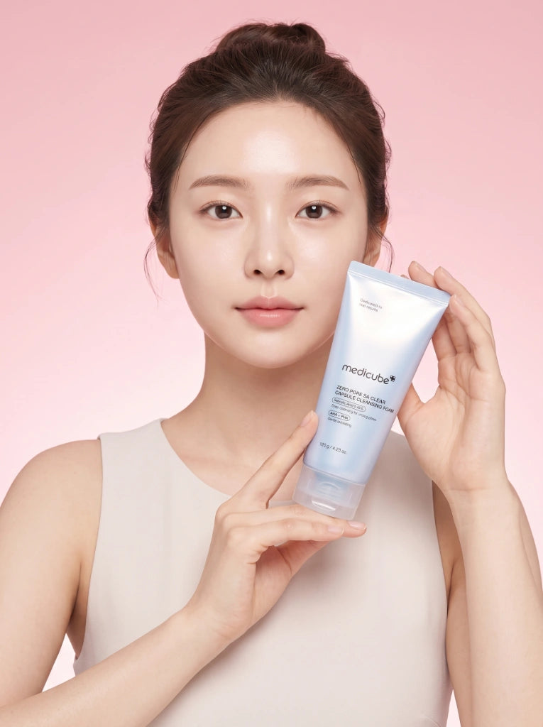 Medicube Zero Pore SA Clear Capsule Cleansing Foam. Modelo sosteniendo el tubo del limpiador facial de poros en la mano.